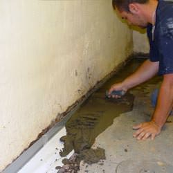 A basement waterproofer installing a perimeter drain system in Gainesville