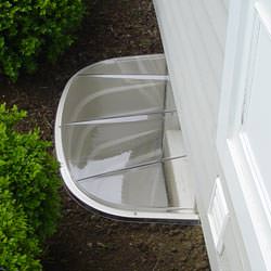 A vinyl basement window and covered window well in Oakton