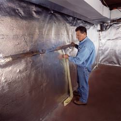 Installation of a radiant heat and vapor barrier on a basement wall in Fairfax Station